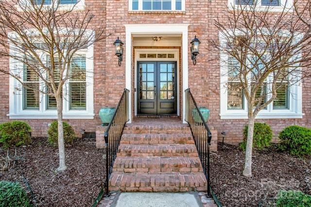 entrance to property featuring french doors and brick siding