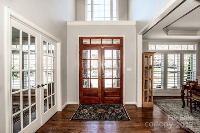 entrance foyer with crown molding, french doors, dark wood-style flooring, and baseboards