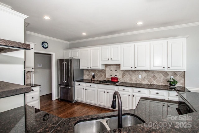 kitchen with a sink, stainless steel appliances, dark wood-type flooring, and ornamental molding