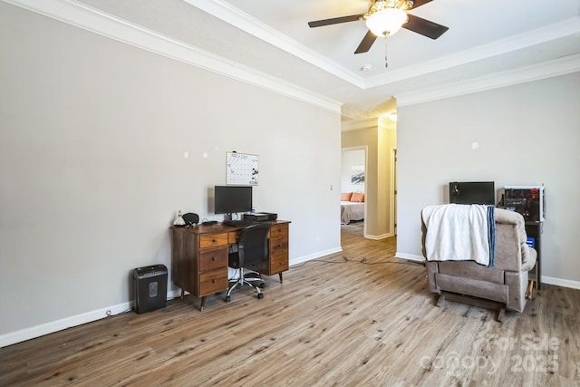 office area with a tray ceiling, crown molding, a ceiling fan, wood finished floors, and baseboards