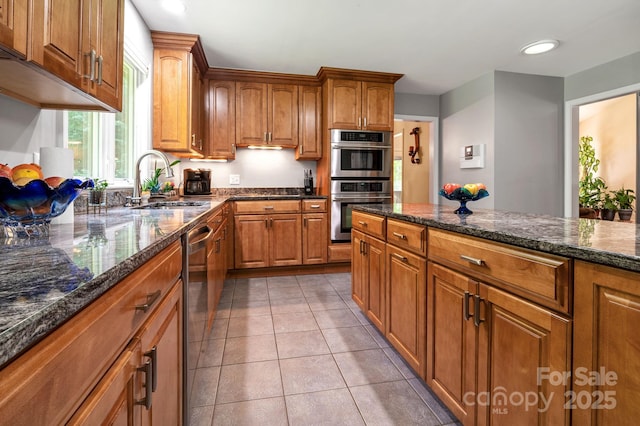 97 Ballantree Dr, Asheville, NC 28803 - kitchen with stainless steel appliances, a sink, brown cabinets, dark stone counters, and recessed lighting