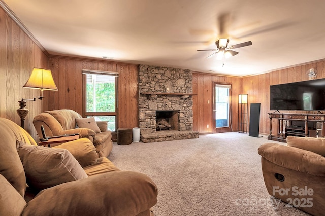97 Ballantree Dr, Asheville, NC 28803 - carpeted living room featuring a stone fireplace, plenty of natural light, wooden walls, a ceiling fan, and crown molding