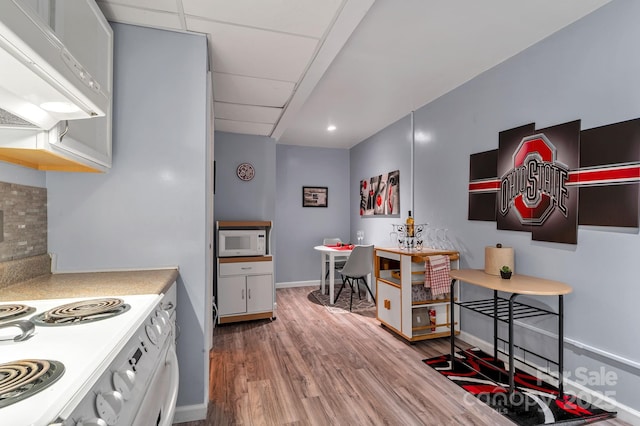 97 Ballantree Dr, Asheville, NC 28803 - kitchen with white appliances, range hood, wood finished floors, light countertops, and baseboards