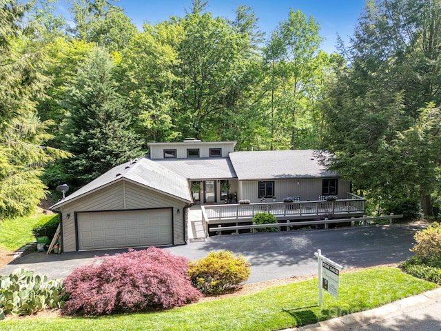 97 Ballantree Dr, Asheville, NC 28803 - mid-century inspired home featuring a garage, a wooden deck, driveway, and roof with shingles