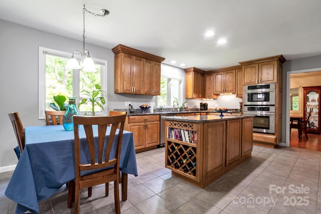 97 Ballantree Dr, Asheville, NC 28803 - kitchen with stainless steel appliances, brown cabinetry, a kitchen island, hanging light fixtures, and recessed lighting