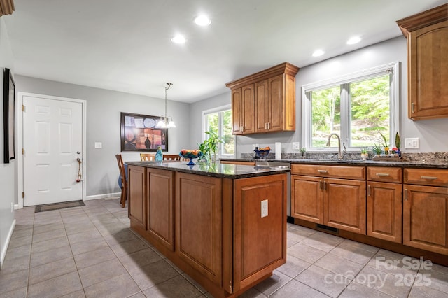 97 Ballantree Dr, Asheville, NC 28803 - kitchen with a sink, a center island, light tile patterned floors, dark stone countertops, and brown cabinets