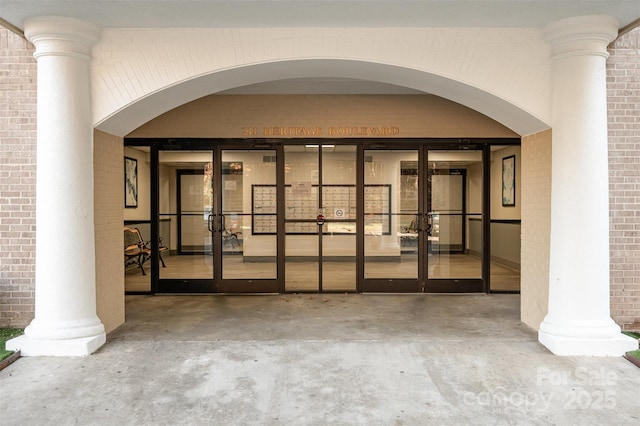 property entrance featuring french doors and brick siding