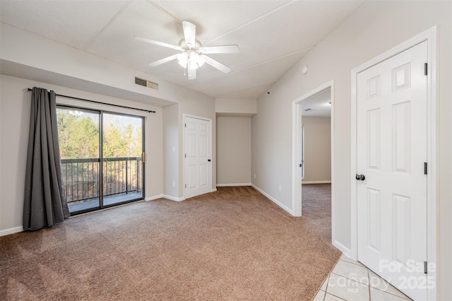 spare room featuring a ceiling fan, light colored carpet, visible vents, and baseboards