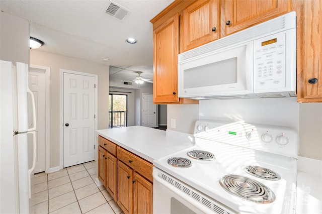 kitchen featuring white appliances, visible vents, light tile patterned flooring, ceiling fan, and light countertops