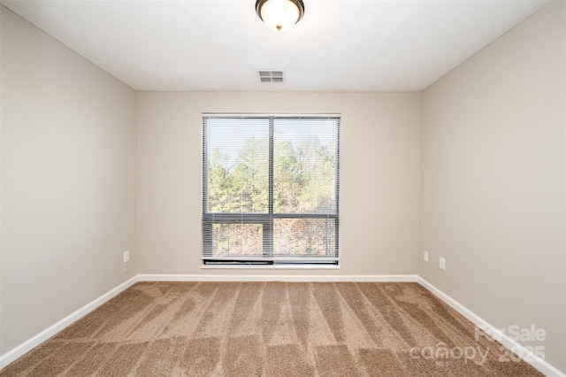 unfurnished room with baseboards, visible vents, and carpet floors