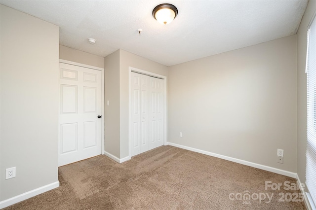 unfurnished bedroom featuring a closet, carpet flooring, and baseboards