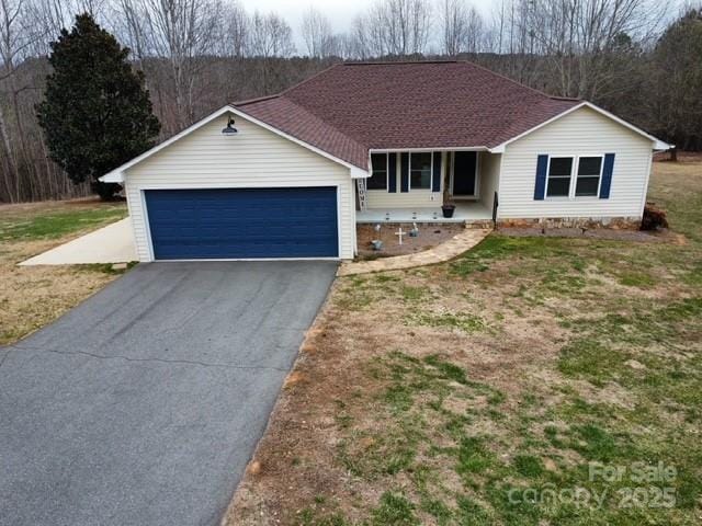 ranch-style home with aphalt driveway, an attached garage, and a shingled roof