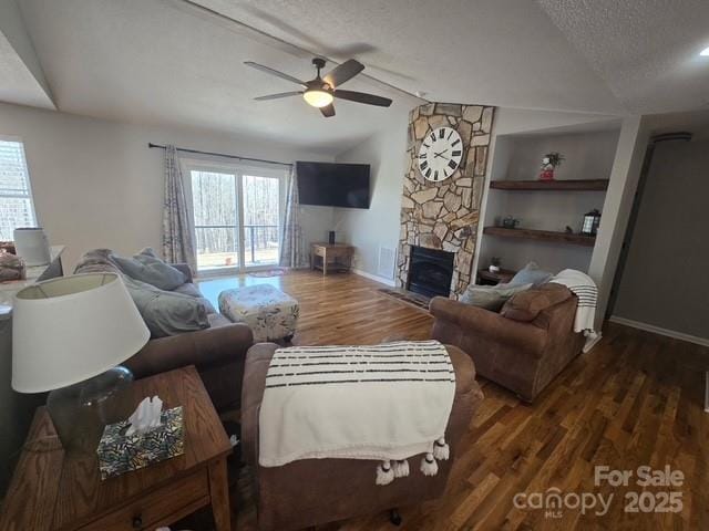 living area with lofted ceiling with beams, wood finished floors, a wealth of natural light, and a textured ceiling