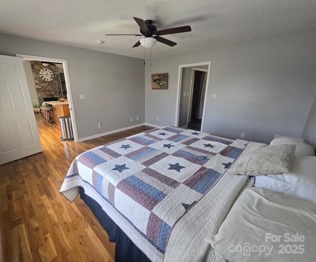 bedroom featuring ceiling fan, baseboards, and wood finished floors