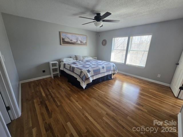 bedroom featuring ceiling fan, wood finished floors, baseboards, and a textured ceiling