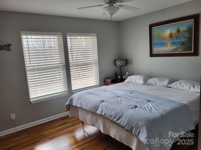 bedroom with ceiling fan, a textured ceiling, baseboards, and wood finished floors