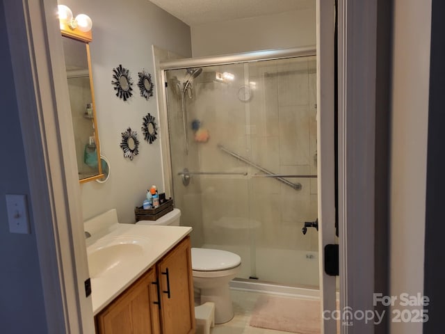 bathroom featuring vanity, toilet, and a stall shower