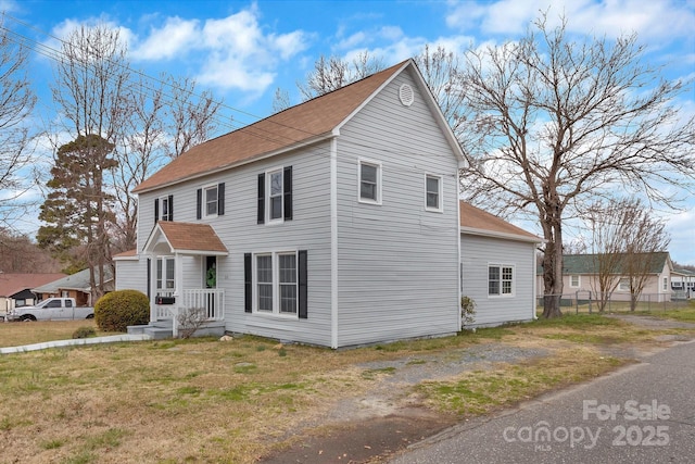 view of front of house with driveway, fence, and a front lawn