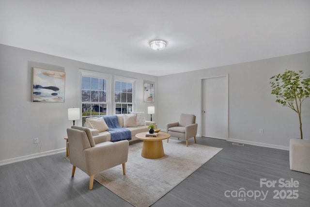 living area with dark wood-style floors, visible vents, and baseboards