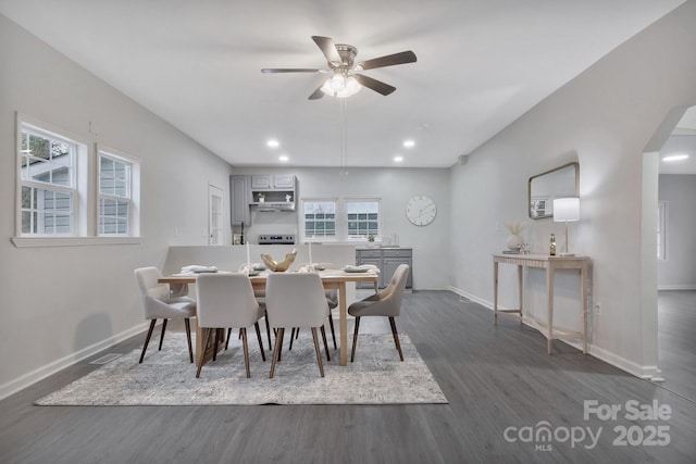 dining space featuring baseboards, arched walkways, dark wood-style floors, ceiling fan, and recessed lighting