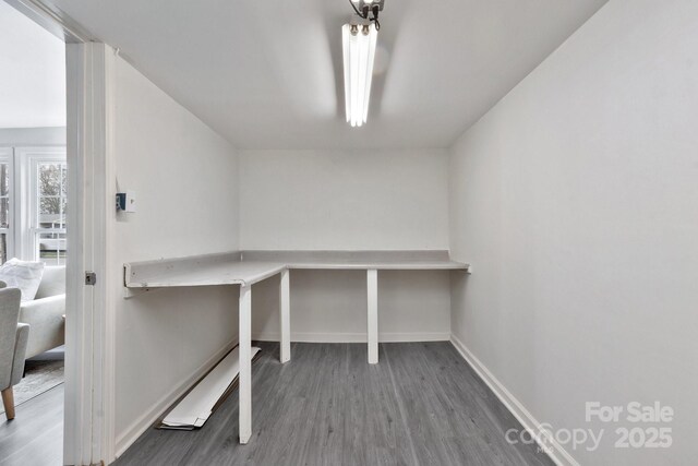 unfurnished office with baseboards and wood finished floors