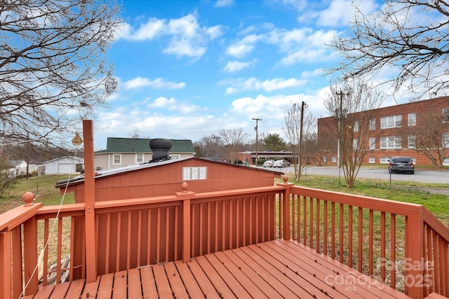 wooden terrace featuring a lawn and fence