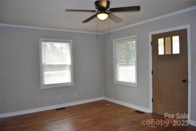 foyer with crown molding, wood finished floors, visible vents, and baseboards