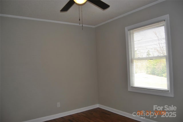 empty room featuring ornamental molding, a ceiling fan, baseboards, and dark wood-style flooring