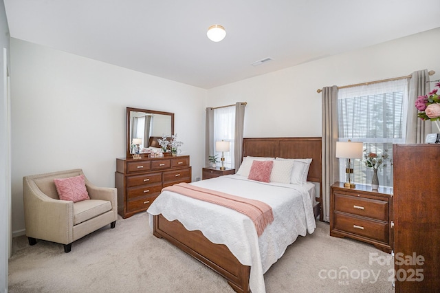 bedroom featuring visible vents and light colored carpet