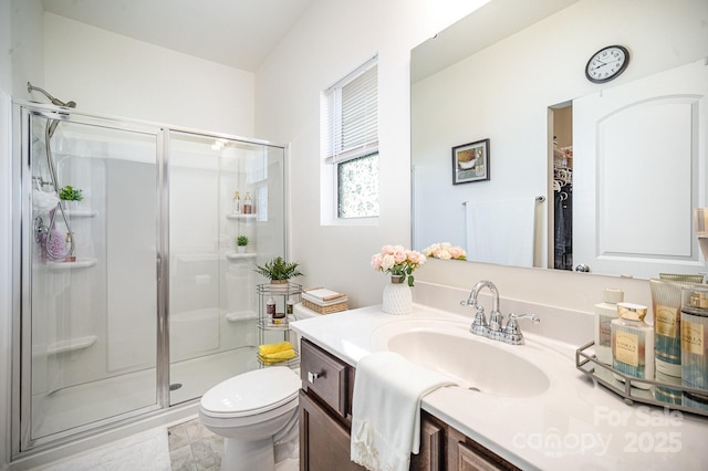 full bathroom with toilet, a stall shower, and vanity