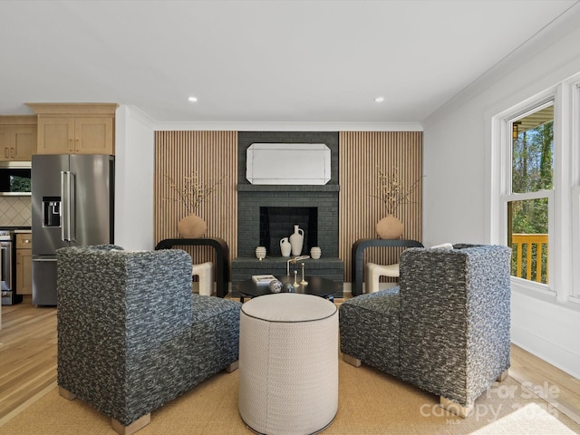 living room with recessed lighting, a brick fireplace, light wood-type flooring, and ornamental molding