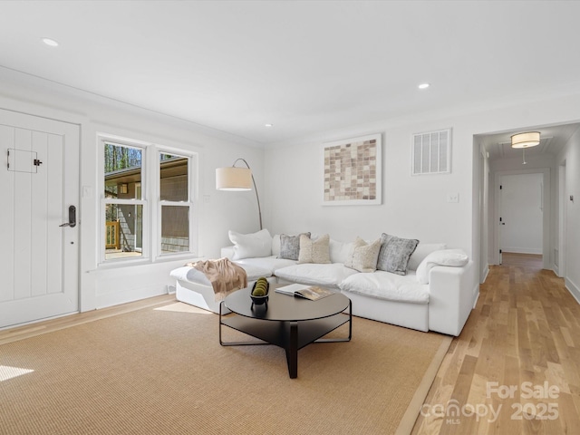 living room with recessed lighting, visible vents, light wood-style floors, and attic access