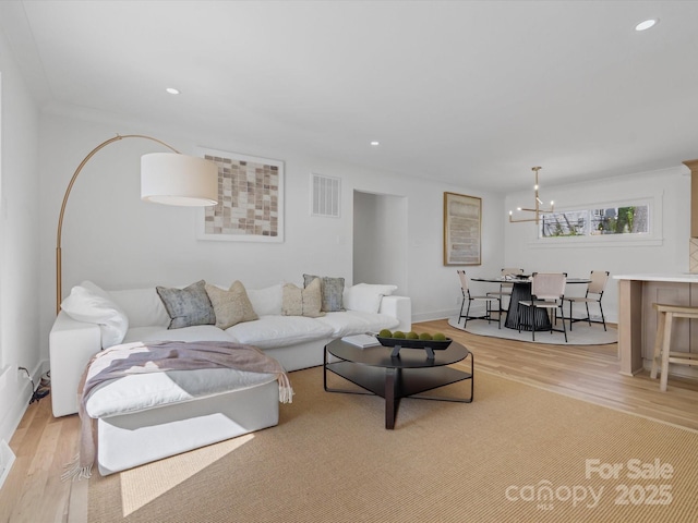 living area with visible vents, recessed lighting, an inviting chandelier, and wood finished floors