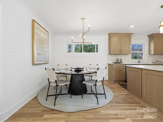 dining room with baseboards, ornamental molding, recessed lighting, light wood-style flooring, and an inviting chandelier