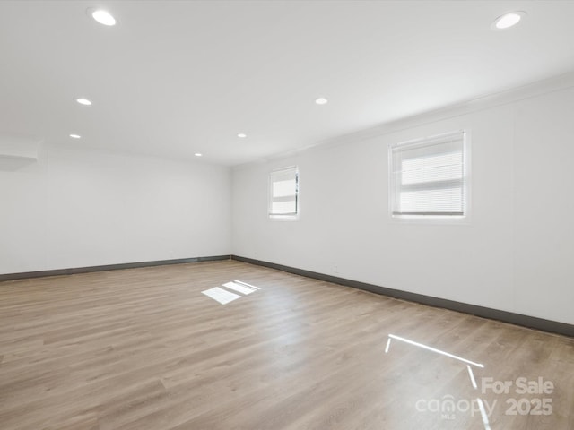 empty room with crown molding, recessed lighting, wood finished floors, and baseboards