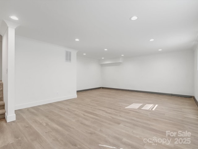 spare room with visible vents, crown molding, and light wood-type flooring