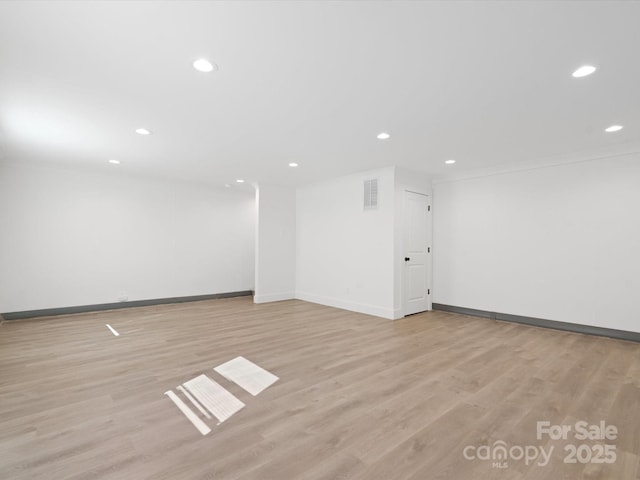 unfurnished room with visible vents, light wood-style flooring, recessed lighting, and baseboards