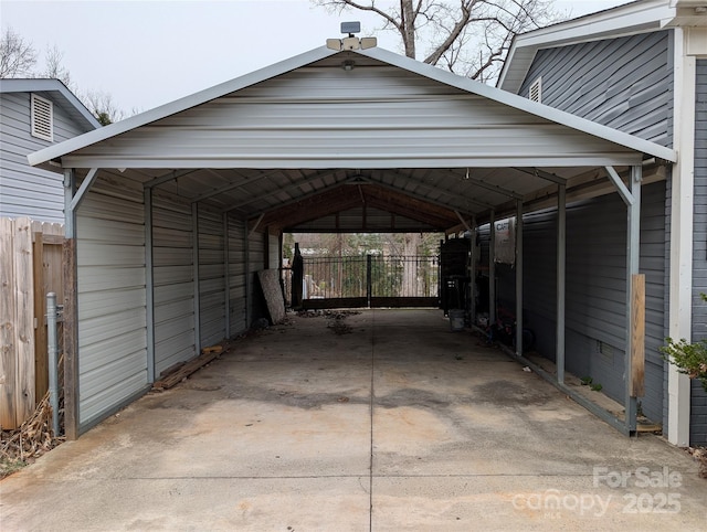 view of vehicle parking with a carport, concrete driveway, and fence