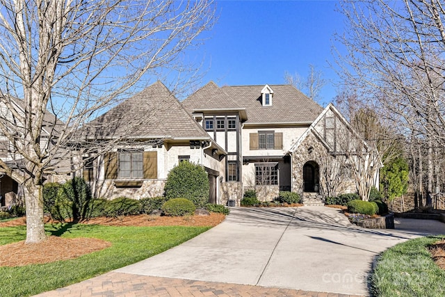 tudor house with stone siding and driveway