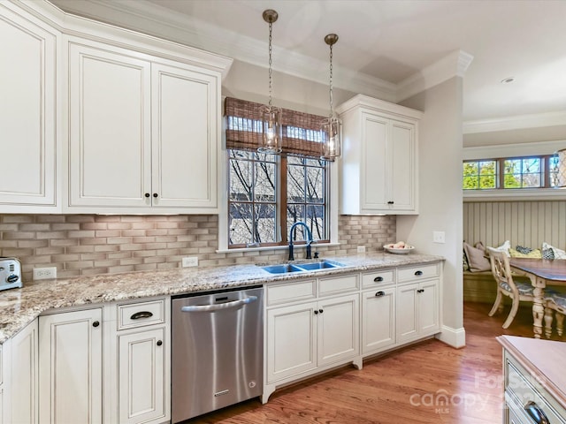 kitchen featuring pendant lighting, ornamental molding, a sink, light wood finished floors, and dishwasher