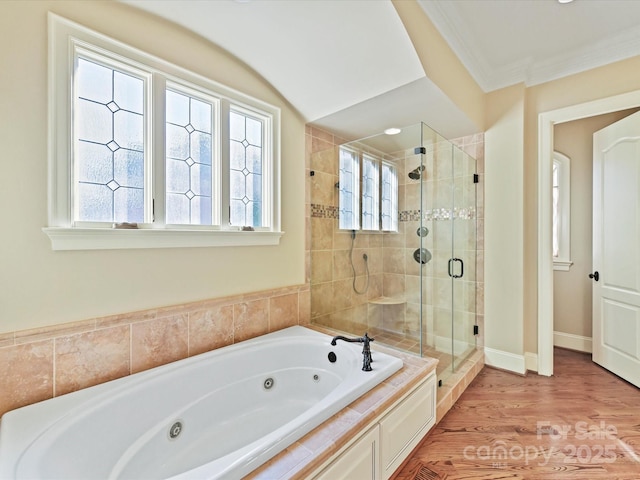 bathroom with a stall shower, ornamental molding, wood finished floors, baseboards, and a whirlpool tub