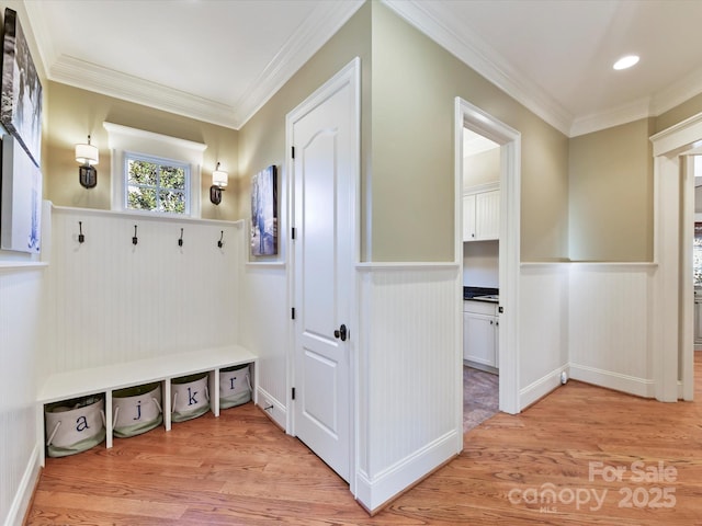 mudroom featuring light wood-style flooring, wainscoting, and ornamental molding