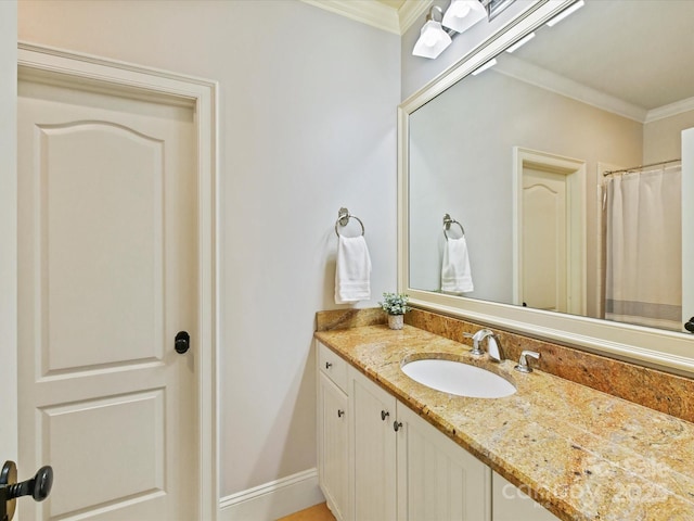 bathroom with baseboards, vanity, and crown molding