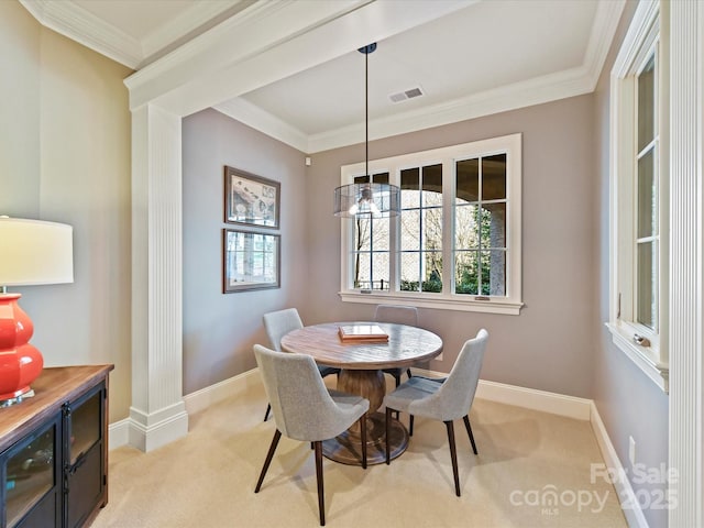 dining room featuring visible vents, baseboards, light colored carpet, and ornamental molding