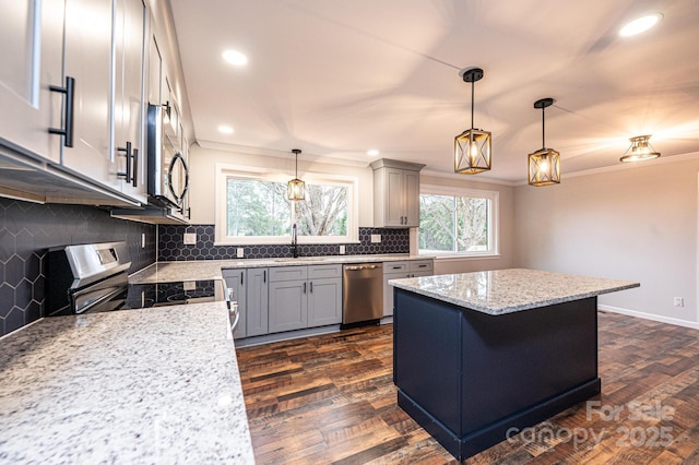 kitchen featuring dark wood-style floors, tasteful backsplash, appliances with stainless steel finishes, and ornamental molding