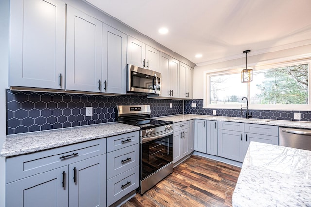 kitchen featuring backsplash, stainless steel appliances, dark wood-type flooring, and a healthy amount of sunlight