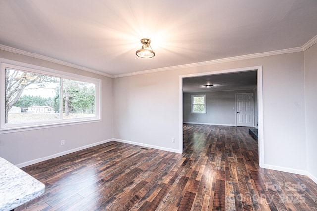 spare room featuring baseboards, hardwood / wood-style floors, and ornamental molding