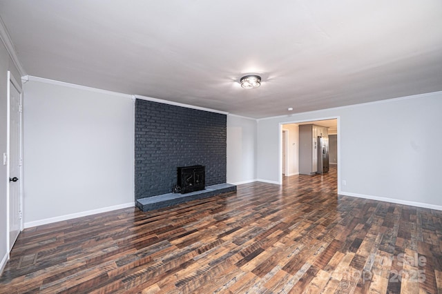 unfurnished living room featuring baseboards, dark wood-style flooring, and ornamental molding