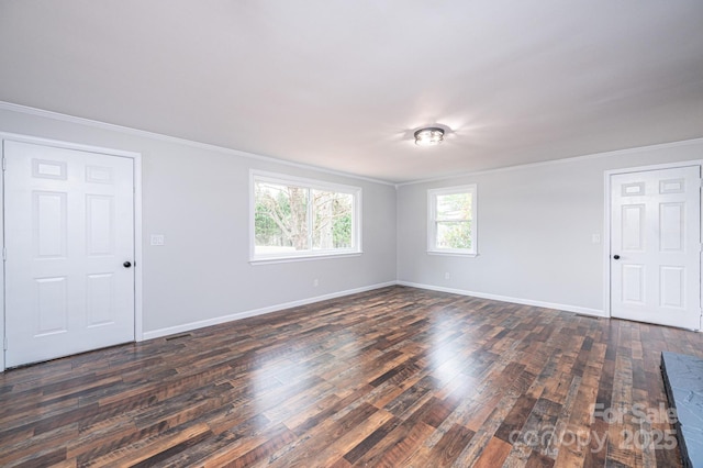 unfurnished room featuring dark wood finished floors, baseboards, and ornamental molding