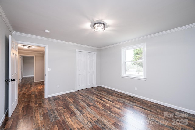 unfurnished bedroom with visible vents, ornamental molding, a closet, baseboards, and dark wood-style flooring